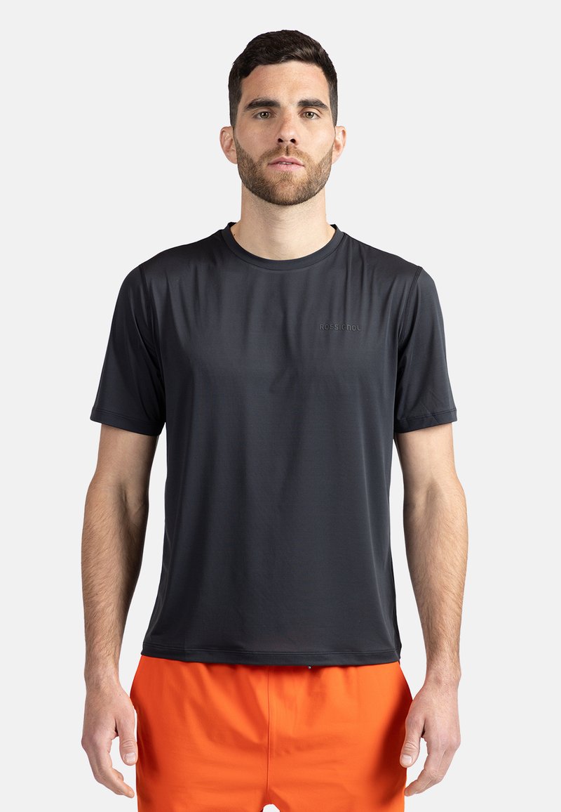 Černé sportovní tričko s krátkým rukávem vyrobené z lehkého, hladkého materiálu. Má kulatý výstřih a decentní logo na hrudi.