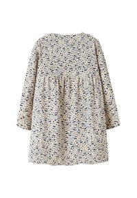 Bloemenpatroon-jurk met een lichtbeige achtergrond en marineblauwe bloemen. Heeft een ronde halslijn en lange mouwen met geplooide details.