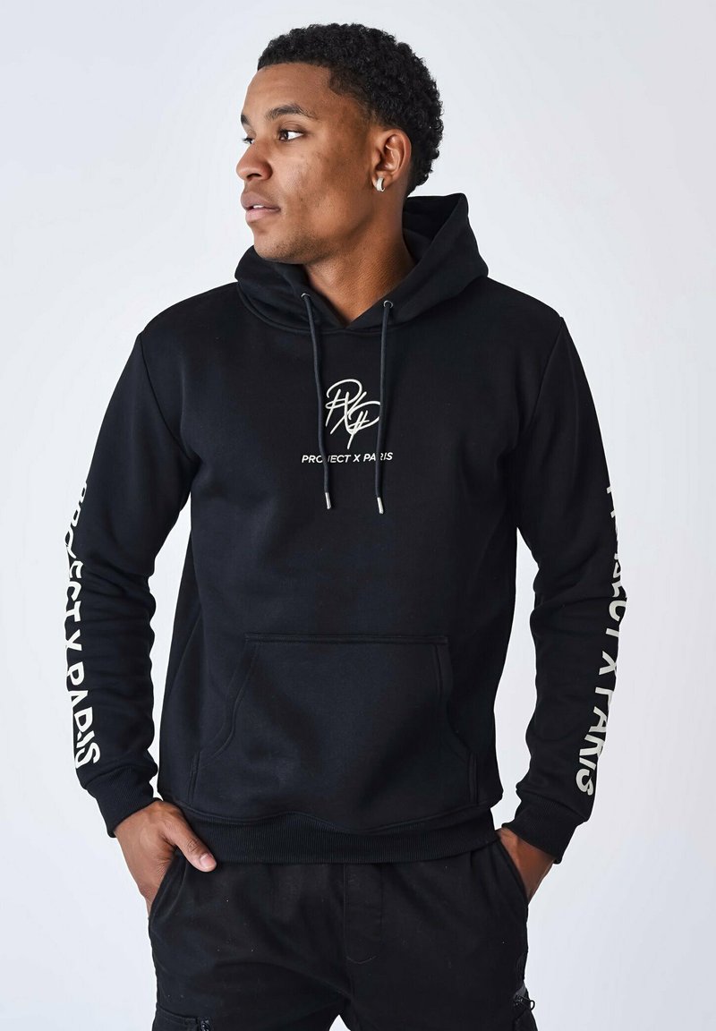 Sudadera negra con bolsillo canguro, cordones y logo blanco "PROJECT X PARIS" en el pecho y las mangas. Fabricada con una tela suave.