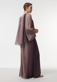 Vloeiende, transparante twee-delige outfit in gradiënttinten van paars. Lange, klokvormige mouwen en een losse pasvorm. Zachte textuur met subtiele draperingsdetails.