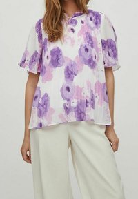 Lätt och ledig blus med korta ärmar gjord av en lättviktig väv, i vit botten med stora lila och rosa blommönster samt subtila veck.