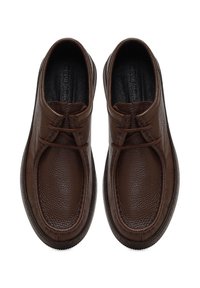 Zapatos de cuero marrón con un acabado texturizado, diseño sin cordones y cordones decorativos. Punta redondeada y forro interior acolchado.