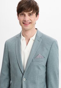 Lichtblauwe blazer van textuurstof, met notch-lapels, een enkele knoopsluiting en een gepatineerde pochet in de borstzak.