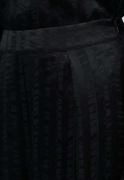 Čierna látka so vzorom a textúrovaným povrchom, s vertikálnymi pruhmi a geometrickými tvarmi. Skrytý pás.