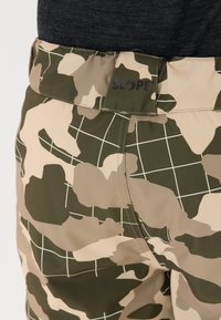 Camo-gepatenteerde shorts met een combinatie van groen en beige met roosteraccenten. Zachte textuur en 'SLOPE'-branding op de tailleband.