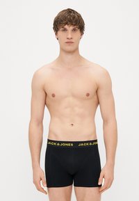Sorte boksershorts med en gul elastisk talje med "JACK & JONES" logo. Klassisk design, blød tekstur, tætsiddende pasform.