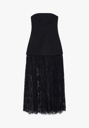 Black strapless dress with a fitted bodice and a flowing lace skirt. The bodice is smooth, complementing the textured lace overlay.