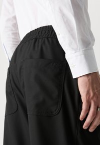 HUGO RAVI - Pantalon classique - black