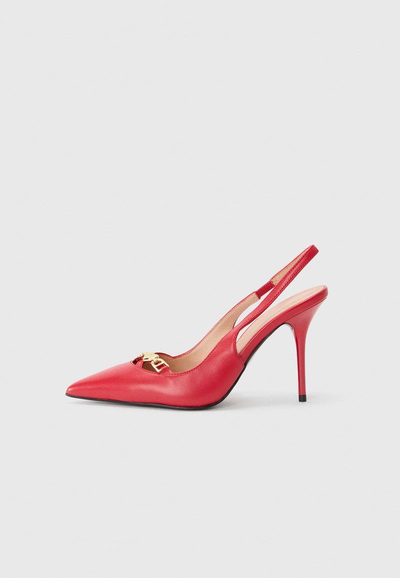 Zapatos de tacón alto de charol rojo, con punta afilada y detalles en dorado. Presentan laterales con cortes y un tacón de aguja.