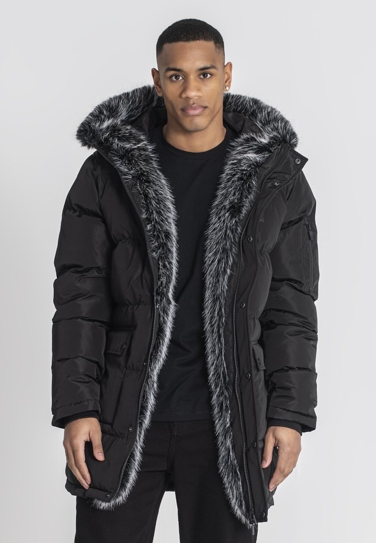Sort puffet jakke med en faux fur hætte og for, med lynlås og trykknaplukning, sidelommer og en let løs pasform.
