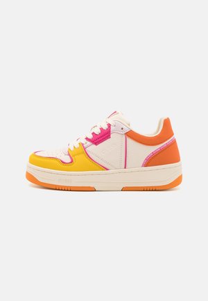 Lav-top sneaker med cremet base, gule og pink overlay, orange hæl, hvide snørebånd og orange sål, sidevisning på hvid baggrund.
