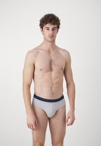 Gray cotton briefs with a navy elastic waistband and white accent stripe; fitted design, soft texture, minimal branding visible.