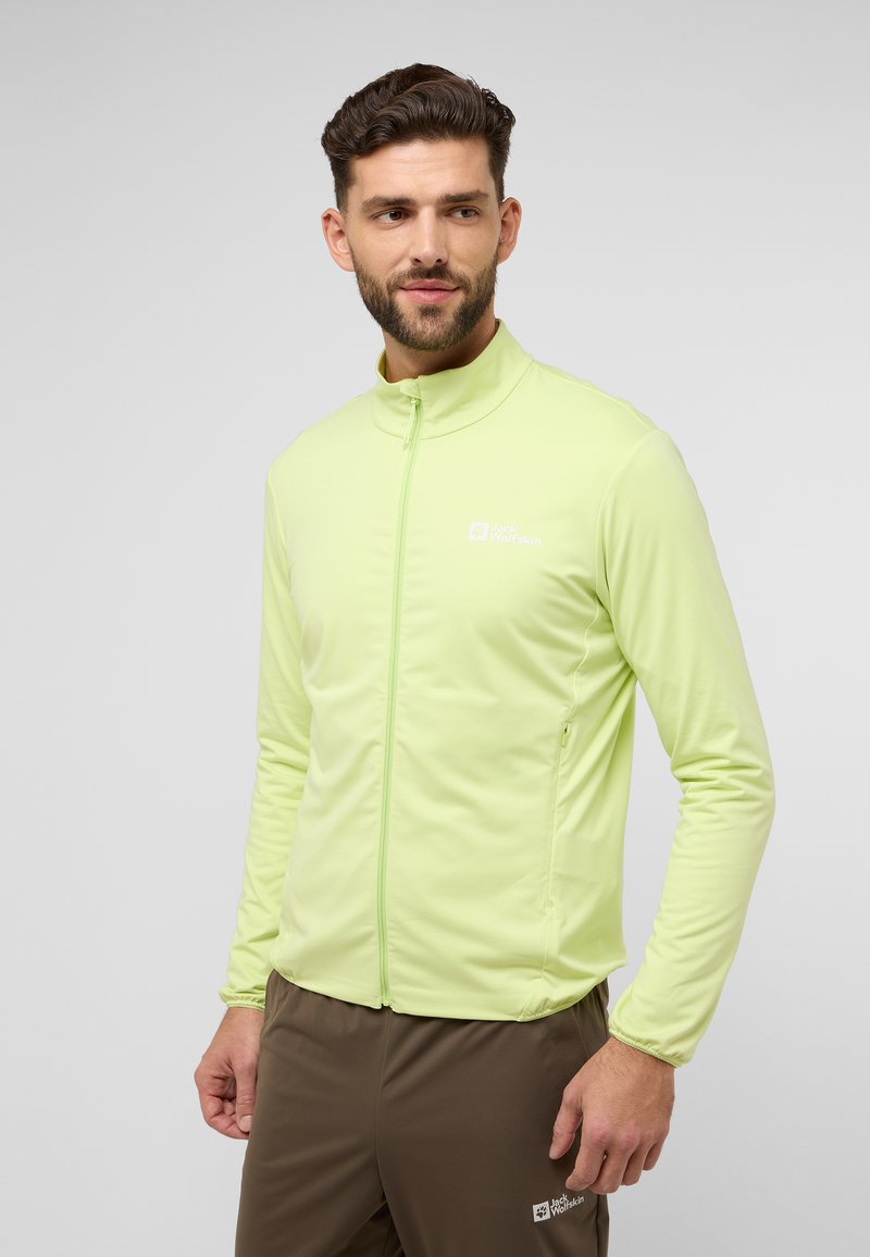 Hellgrüne Sportjacke mit hohem Kragen, Reißverschluss und mit Reißverschluss versehenen Taschen. Glatte Textur mit einem Logo auf der Brust.