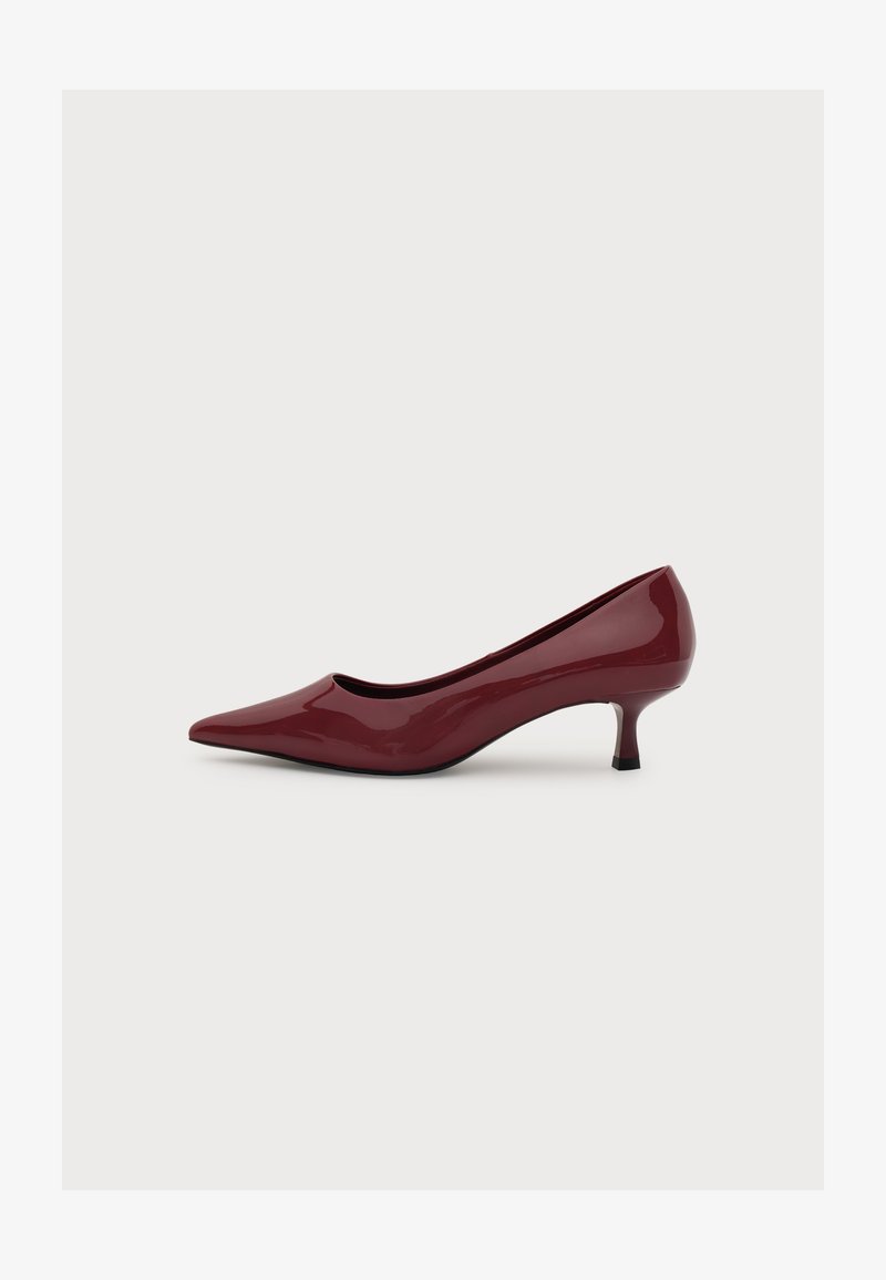 Escarpin bordeaux brillant à bout pointu et petit talon kitten, vue latérale, présenté sur un fond blanc uni.