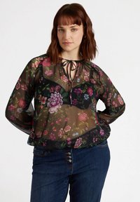 Bluză neagră transparentă cu modele florale în nuanțe de roz, violet și albastru. Are un guler legat și mâneci lungi; material ușor.