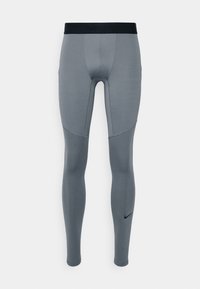 Graue Nike Pro Kompressionsleggings mit schwarzem Bund und schwarzem Nike-Swoosh-Logo nahe dem Knöchel, auf weißem Hintergrund präsentiert.