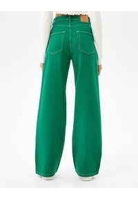 Gröna vida jeans i denim med hög midja, två bakfickor och en läderlapp vid midjan.