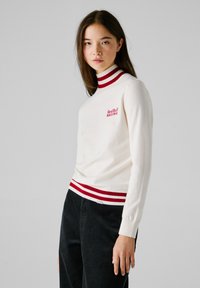 Maglione bianco a maglia con colletto e orlo a coste rossi con strisce bianche, logo ricamato "Red Bull RACING" sul petto.