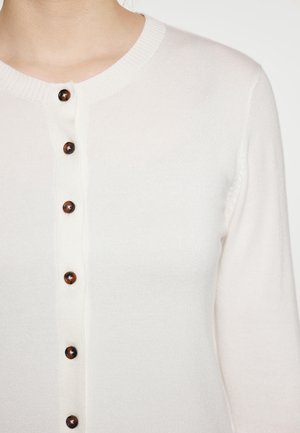 Witte gebreide cardigan met ronde hals, voorzien van een rij donkerbruine, ronde knopen aan de voorkant en geribbelde manchetten.