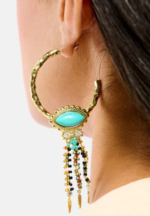 Boucle d'oreille créole en or avec une pierre centrale turquoise, ornée de perles colorées et de trois accents pendants, présentant une finition texturée.