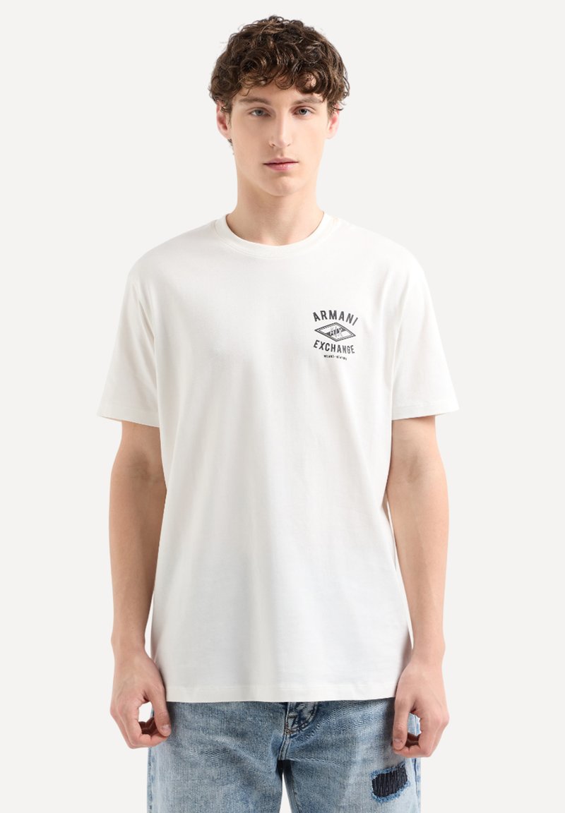 T-shirt bianco in cotone con un piccolo logo nero "Armani Exchange" sul lato sinistro del petto. Maniche corte e scollatura tonda.