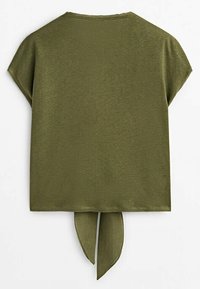 Haut vert olive à manches courtes avec un col rond et un détail noué dans le dos suspendu à l'ourlet.