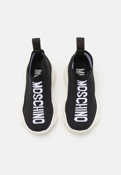 Black knit slip-on sneakers with white "MOSCHINO" text, rounded soles, textured fabric, and pull tabs on the back for easy wear.