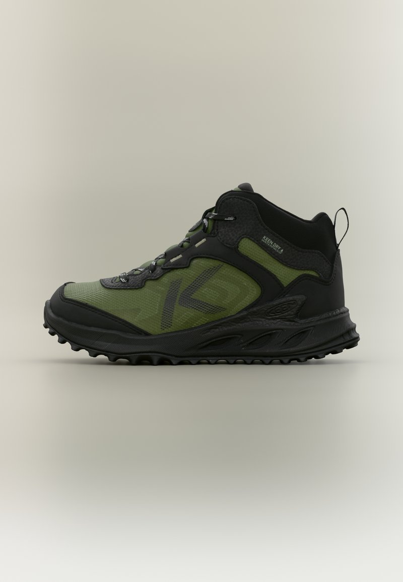 Περπατητικό παπούτσι μεσαίου ύψους με πράσινο υφαντό πάνω μέρος, μαύρες συνθετικές λεπτομέρειες, υφή στη φτέρνα και ανθεκτική μαύρη λαστιχένια σόλα.
