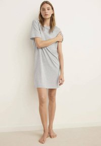 Grå bomulds t-shirt kjole med korte ærmer, løs pasform, der når midt på låret, glat tekstur, minimalistisk design og uden synlige mønstre eller accenter.