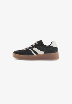 Zapatilla de cuero negro con rayas blancas, puntera redonda, cordones rosas y suela texturizada en color marrón. Diseño bajo con un cuello acolchado.
