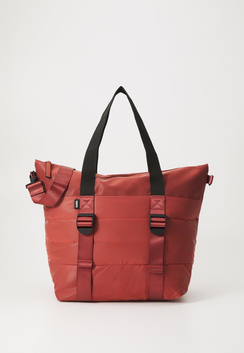 Rød polstret tote bag med svarte doble håndtak og justerbar stropp. Glatt, blank tekstur med horisontal søm og spenneinnslag.