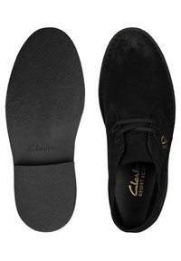 Black suede desert boots with a round toe, lace-up front, and rubber sole. The insole features a textured surface for grip.