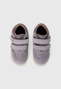 Lila Wildlederschuhe mit zwei Klettverschlüssen, runder Zehenpartie und gepolstertem Innenraum. Gummisohle mit strukturiertem Boden für besseren Halt.