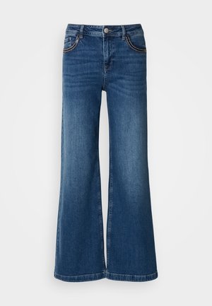 Jean large en denim bleu foncé. Dispose de cinq poches avec des coutures contrastées, d'un bouton en métal et d'un design classique à coupe droite.
