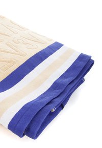 Strandhanddoek, met een gestructureerd beige oppervlak en een blauw-wit gestreepte rand. Netjes gevouwen, waardoor het zachte materiaal en de levendige kleuren worden getoond.