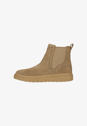 Tan ruskind Chelsea-støvle med elastiske sidepaneler, trækflig ved hælen og tyk gummisål, vist i sideprofil mod hvid baggrund.
