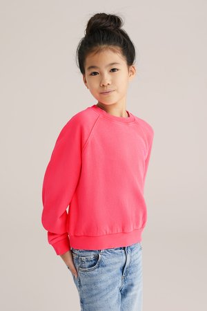Sudadera rosa con cuello redondo, puños acanalados y dobladillo. Fabricada en tejido suave con un corte relajado y un sutil detalle de logo en el pecho.