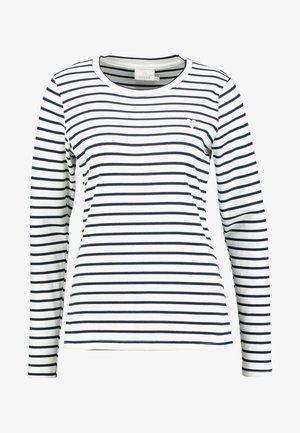 White long-sleeve shirt with navy horizontal stripes and a small pink heart logo on the left chest. Cotton blend, crew neck design.