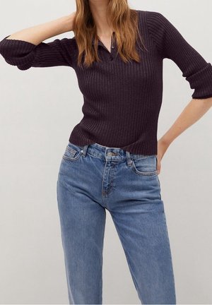 Geribbelde donkerpaarse gebreide top met een kraag, gecombineerd met lichtblauwe high-waisted denim jeans. Beide hebben een aansluitende pasvorm en opgerolde mouwen.