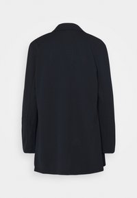 Blazer formal negro visto desde atrás con mangas largas y un cuello clásico, mostrado sobre un fondo blanco liso.
