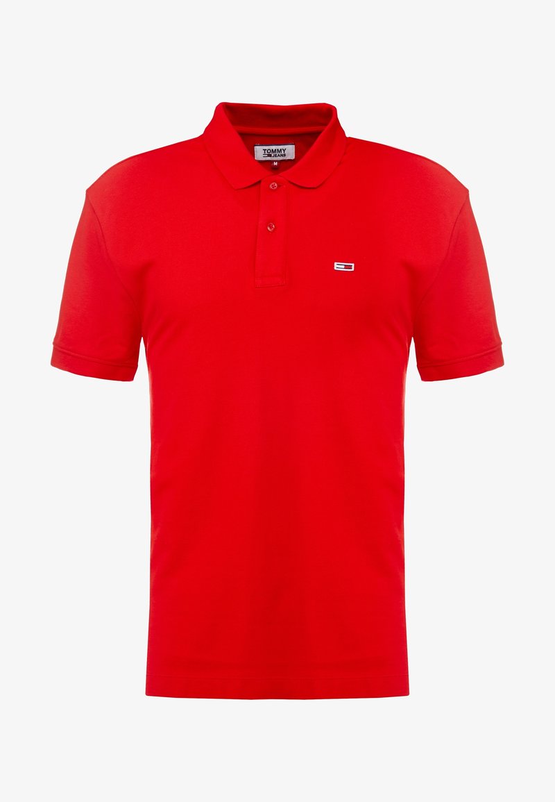 Polo rouge en coton, doté d'un col classique et de manches courtes. Comprend un petit logo brodé sur le côté gauche de la poitrine.