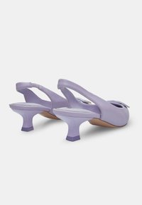 Lila slingback petke z sijočo površino, zaobljenimi prsti in prozornimi blok petami. Imajo nastavljiv trak in gladko teksturo.