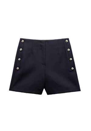 Tummansiniset shortsit, jotka on valmistettu sileästä kankaasta, ja joissa on pystysuorat poimutukset sekä kuusi hopeista nappisomistetta sivussa.