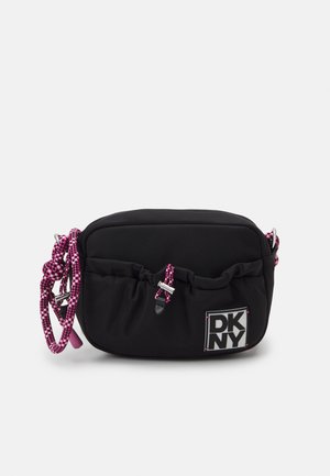 Black nylon crossbody bag with pink checkered rope strap, gathered top, and DKNY logo patch. Features silver-tone hardware and side accents.