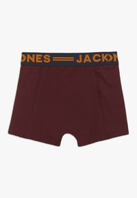 Bordové boxerské šortky s tmavomodrým pásom a nápisom "JACKSON" v žltom písmene. Mäkko materiál, hladká textúra, stredná dĺžka dizajnu.