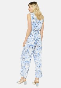 Gėlėtas kombinezonas šviesiai mėlynos ir baltos spalvos, su laisvu siluetu, be rankovių dizainu, elastine juosmens juosta ir plačiomis kojos dalimis su plazdančia tekstūra.