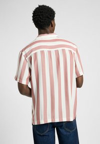 Kurzarmhemd mit abwechselnden rosa und weißen vertikalen Streifen, aus leichtem Gewebe mit geradem Saum und Rückenfalte.