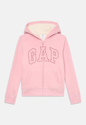 Vaaleanpunainen lasten vetoketjuhuppari, jossa on "GAP" -teksti edessä ja fleecvuorattu huppu. Hupparissa on etutaskut ja ribbauskudoksesta valmistetut hihansuut.