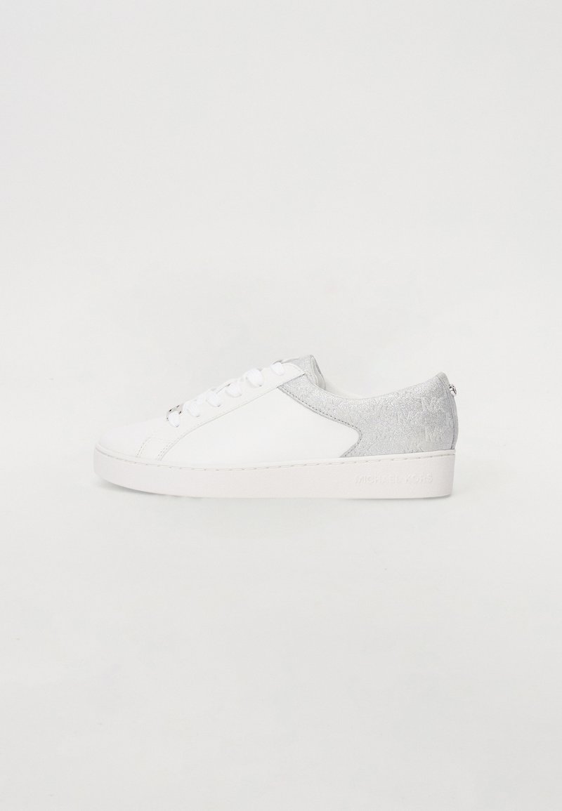 Fehér sneaker sima bőr felsőrésszel, ezüstszürke velúr díszítéssel a sarkon, kerek orral és lapos gumitalppal. Fűzős záródással rendelkezik.