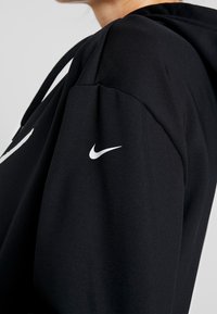 Felpa nera con cappuccio in tessuto morbido, con il logo bianco Nike sulla manica sinistra e cappuccio regolabile.